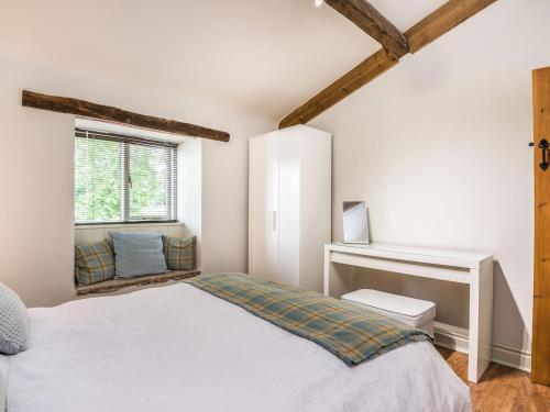 a bedroom with a white bed and a window at Teal Barn Annexe in Saint Weonards