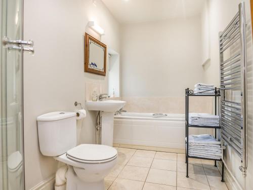 a bathroom with a toilet and a sink and a tub at Teal Barn Annexe in Saint Weonards