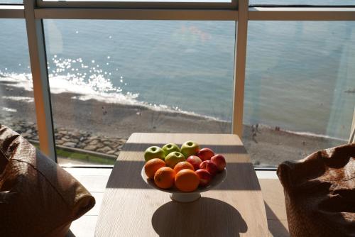 a bowl of fruit on a table in front of a window at RUMI Hotel in Batumi