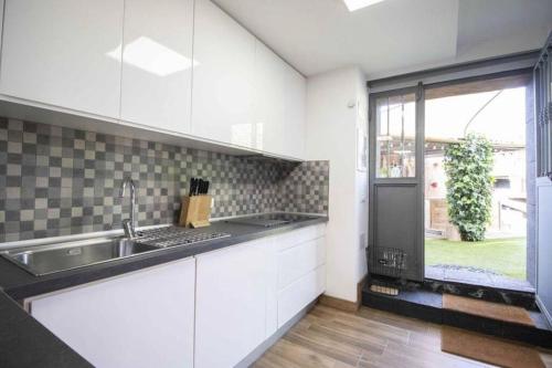 a kitchen with white cabinets and a sink and a window at Villa Canales in La Matanza de Acentejo
