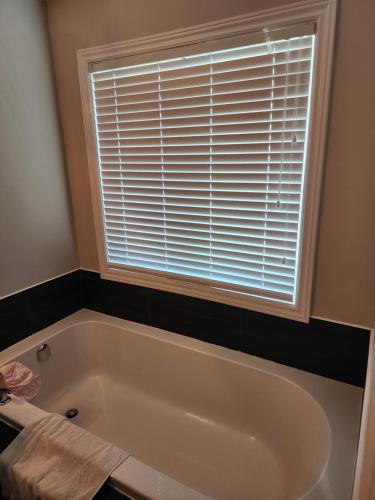uma banheira branca na casa de banho com uma janela em Home of the Sultan em Ottawa
