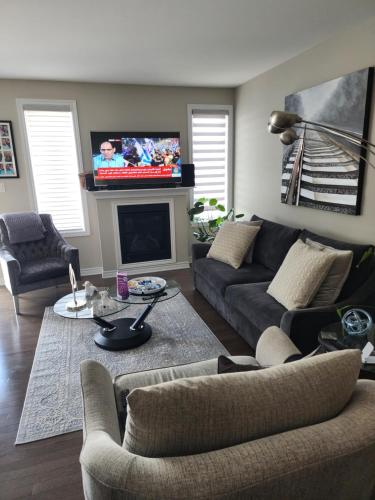 a living room with a couch and a tv on the wall at Home of the Sultan in Ottawa