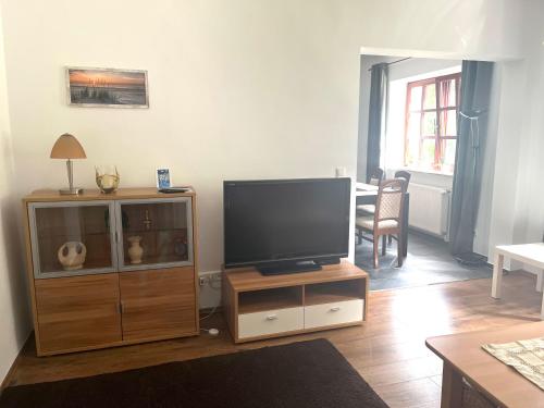 a living room with a flat screen tv on a wooden entertainment center at Natur&Meer: Ferienwohnung im idyllischen Landhaus in Ahrenshagen