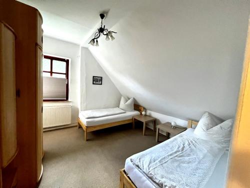 a bedroom with a bed and a chair and a window at Natur&Meer: Ferienwohnung im idyllischen Landhaus in Ahrenshagen