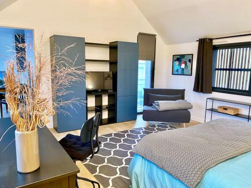 une chambre avec un lit, un bureau et une chaise dans l'établissement Magnifique T2 neuf, proche gare, parking facile, à Vannes