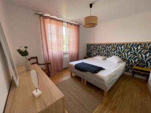 Dormitorio pequeño con cama y mesa en Maison familiale 8 p en vallée de Dordogne - Lot, en Tauriac