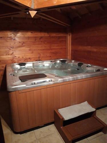 a large hot tub in a room with wooden walls at Maison de campagne à 15 km du ZooParc de Beauval in Luçay-le-Mâle