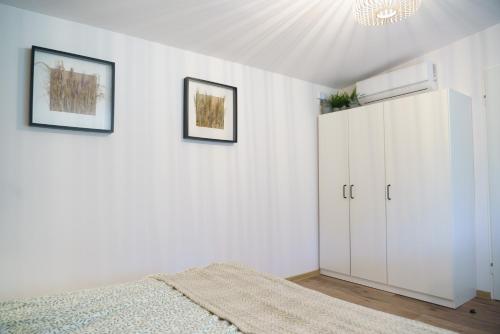 a bedroom with a bed and a white cabinet at Sławica Inn domek letniskowy nad jeziorem in Sławica