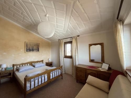 1 dormitorio con cama, espejo y sofá en Apartments Krnjic, en Umag