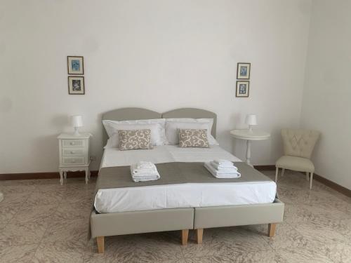a bedroom with a large bed and two chairs at Porta Napoli Rooms in Lecce
