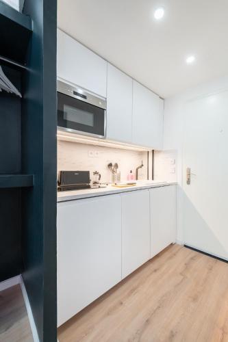 une cuisine avec des armoires blanches et un évier dans l'établissement Candy Room, à Marseille