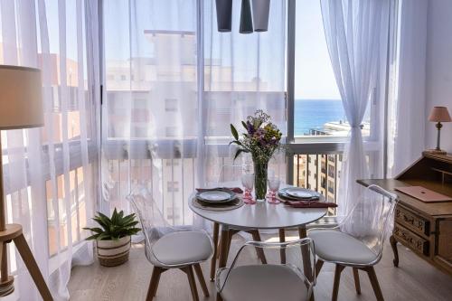 a dining room with a table and chairs and a window at Apartamento Sofia en CALPE in Calpe