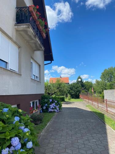 a building with a balcony and flowers on the side at MARIA in Varaždin