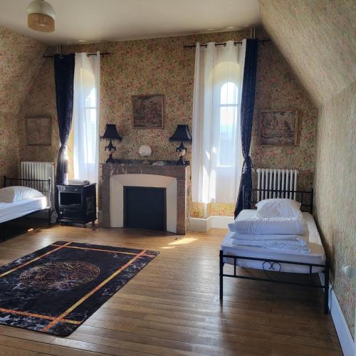 聖高登斯的住宿－Château / Manoir de Saint-Gaudens，一间卧室设有两张床和一个壁炉