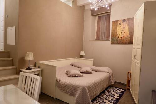 ein kleines Schlafzimmer mit einem Bett und einem Kronleuchter in der Unterkunft Corte Lavarini The Magic At Sight in Fumane