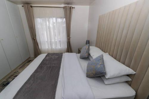 um quarto com uma grande cama branca com almofadas em Havens corner em Sandton