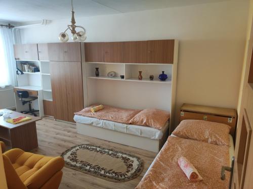 a small bedroom with two beds and a desk at Apartmán City in Zvolen