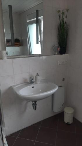 y baño con lavabo blanco y espejo. en Ferienwohnung Am Kurpark en Bad Camberg
