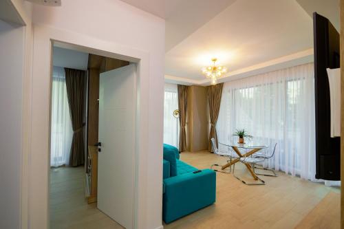 a living room with a blue couch and a table at Blue Luxury Apartment Lake On in Mamaia