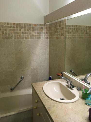 une salle de bain avec un lavabo et une baignoire dans l'établissement T2 Cosy proche de la mer, à Cassis