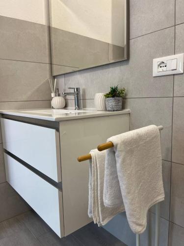 y baño con lavabo, espejo y toallas. en Central Rooms Posada, en Posada