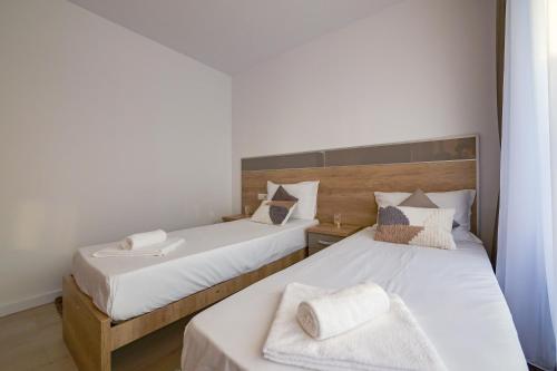 a bedroom with two beds with white sheets at Blue Luxury Apartment Lake On in Mamaia