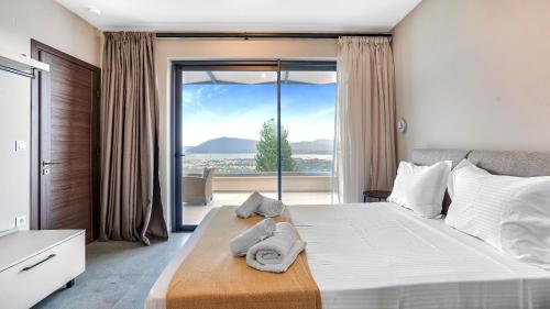 a bedroom with a large bed with a large window at Ecstasy Luxury Villas in Apolpaina