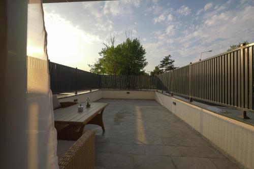 a patio with a wooden bench on a balcony at Blue Luxury Apartment Lake On in Mamaia