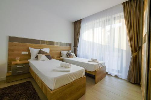 um quarto de hotel com duas camas e uma janela em Blue Luxury Apartment Lake On em Mamaia