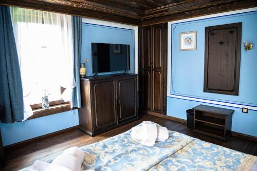 a blue room with a bed and a television at Къща ЕТНО in Koprivshtitsa