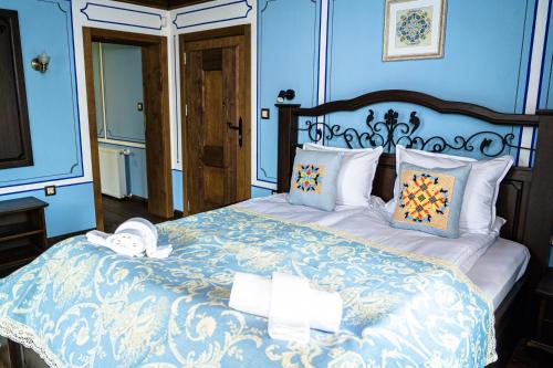 a bedroom with a large bed with blue walls at Къща ЕТНО in Koprivshtitsa
