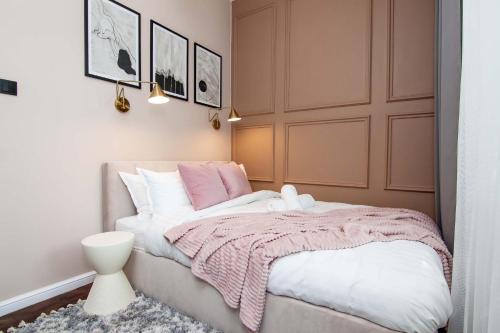 una camera con un letto con una coperta rosa e bianca di Cztery Czaple a Chełm