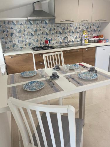 a kitchen with a table with chairs and plates on it at Vista al Tramonto B&B in Falerna