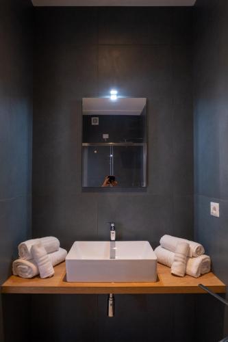 a bathroom with a sink and a mirror and towels at Nautika Suites in Alghero