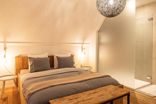 De Gulle Beemden في Hulshout: غرفة نوم بسرير كبير وثريا
