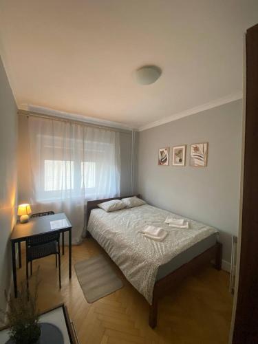 a small bedroom with a bed and a table at HALBY rooms Nowolipki 15 in Warsaw