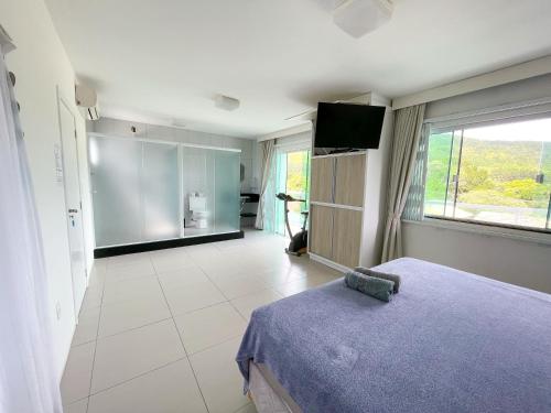 a bedroom with a bed and a tv in a room at Ipê Palmas Hostel in Governador Celso Ramos