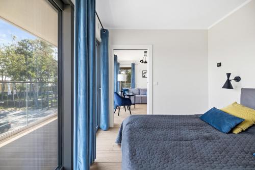a bedroom with a bed and a large window at Solaris Darłówko Premium Emilia Strupiechowska in Darłowo
