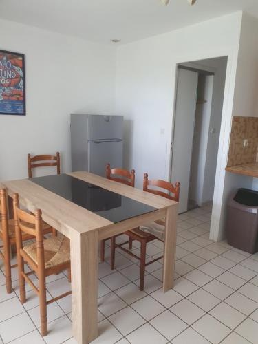 a kitchen with a wooden table and chairs at The Gare Gondrin in Gondrin
