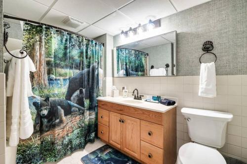 uma casa de banho com uma cortina de chuveiro com um cão em Bear Pause Retreat/Steps to Pkwy/With Indoor Pool em Gatlinburg
