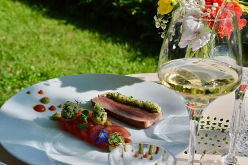 a plate with a piece of meat and a glass of wine at Chateau du Clos de la Ribaudiere - Teritoria in Chasseneuil-du-Poitou