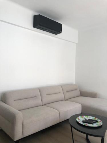 a living room with a couch and a tv on a wall at HELIOS in Knokke-Heist