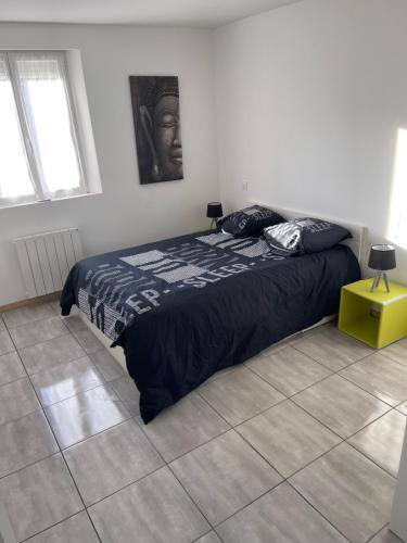 sypialnia z łóżkiem z czarną kołdrą w obiekcie Petite maison avec 2 chambres 