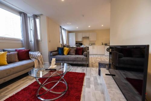 a living room with a glass table and a couch at Pristine Relocation 3 beds Apartment in London
