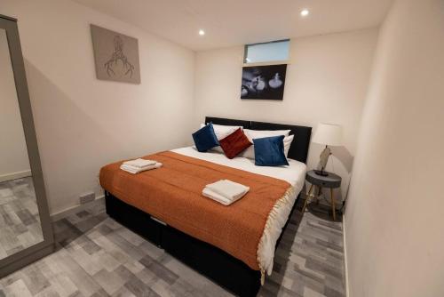 a bedroom with a large bed with blue pillows at Pristine Relocation 3 beds Apartment in London