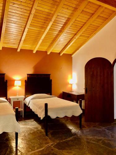 a bedroom with two beds and a wooden ceiling at Casa do Forno Évora retreat in Redondo