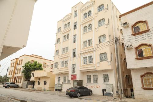 a car parked in front of a white building at RED-7 - Alwadi Salalah in Salalah