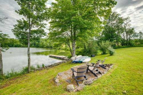 a couple of chairs and a boat on a lake at Lakeside Gem Hot Tub and Game Room in Hancock in Deposit
