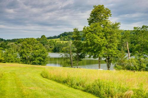 a grassy field with a lake in the background at Lakeside Gem Hot Tub and Game Room in Hancock in Deposit