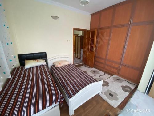 two twin beds in a bedroom with wooden cabinets at Finike Apart in Finike